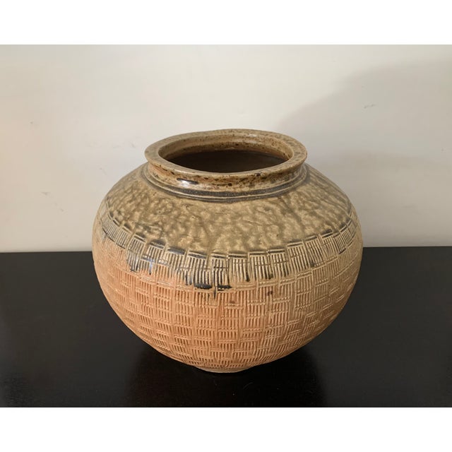 A large 'ash-glazed' stoneware jar, China, Eastern Han dynasty, circa 2nd century AD; ; 11 ½ in. (31.8 cm.) high. The jar...