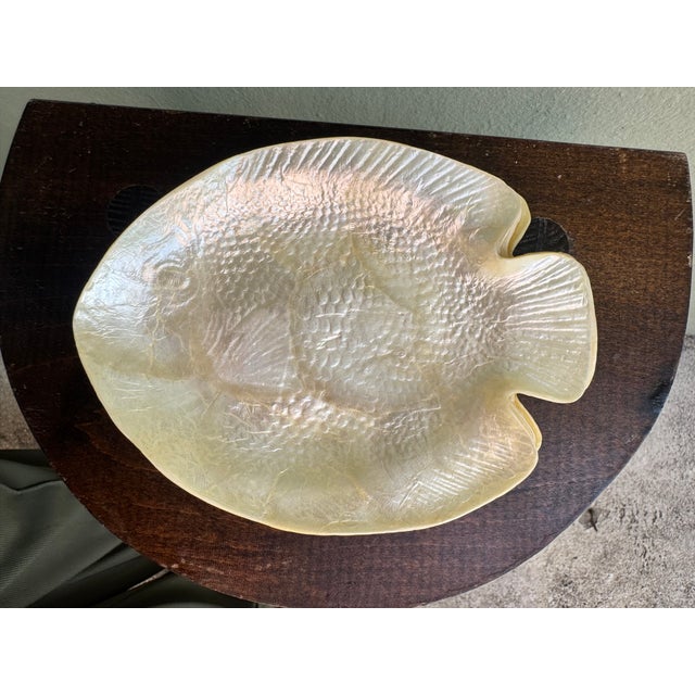 A luminous set of six fish-form dishes hand-carved from genuine mother of pearl, each shaped as a flat tropical fish with...