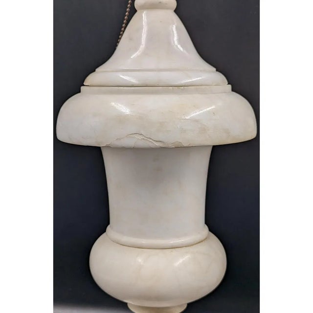 A striking pair of Mid-Century Modern alabaster table lamps featuring beautifully turned, urn-form silhouettes with...