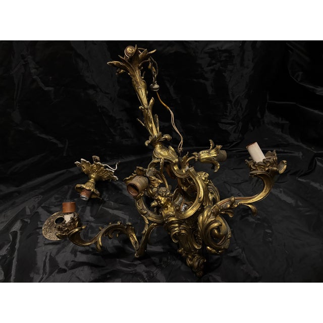 An exquisite 19th-century gilt-bronze three-arm chandelier showcasing exceptional craftsmanship and timeless European...