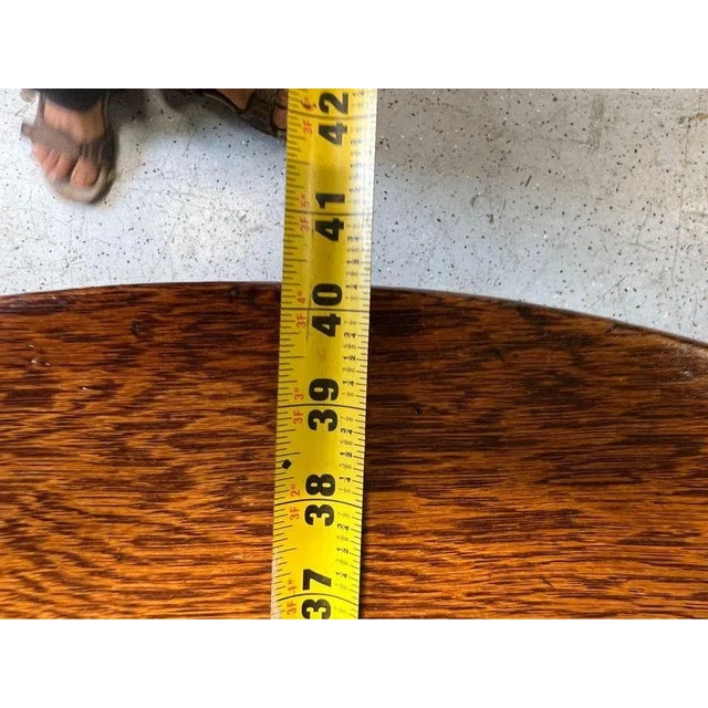 Antique Tiger Oak Round Dining Table. Circa late 19th century to early 20th century The center split pedestal is square...