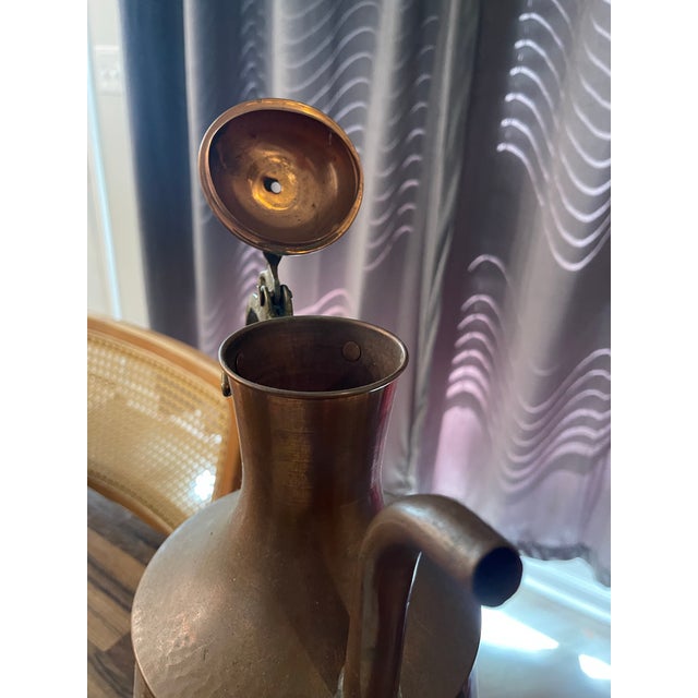 This antique 19th century Turkish hammered copper pitcher is a rare and unique piece that exudes historical charm. The...