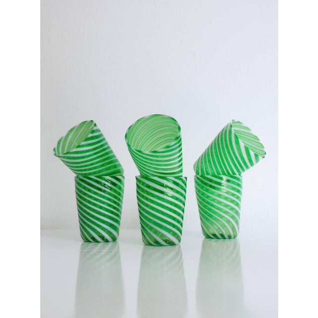 Elegant, refined, resistant. Splendid Murano glass table glasses in green color made with the twisted filigree technique...