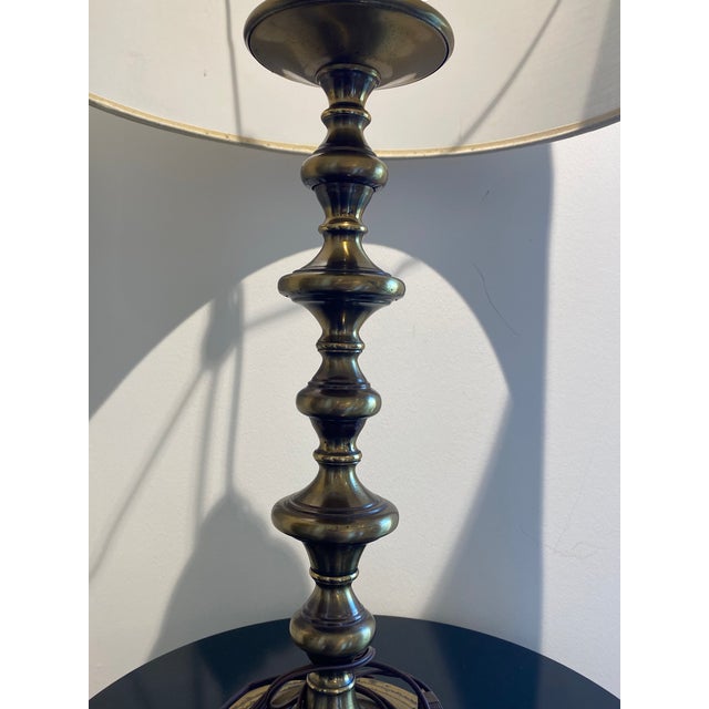 A beautiful vintage-style brass lamp that features a distinctive, segmented column design with a burnished, aged patina....