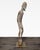 This is a unique hand-carved wooden sculpture featuring a slim, elongated figure with detailed facial features and a...