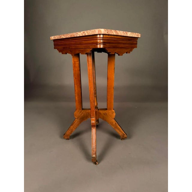 A beautiful example of American Eastlake Victorian design, this walnut marble-top tea table showcases the geometric...