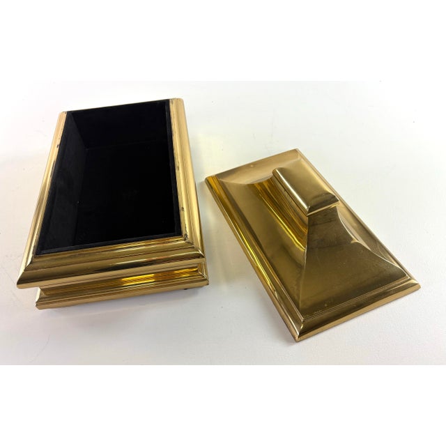 This is a mid-century vintage solid brass trinket box by Chapman. This brass trinket box has a black velvet lining to the...