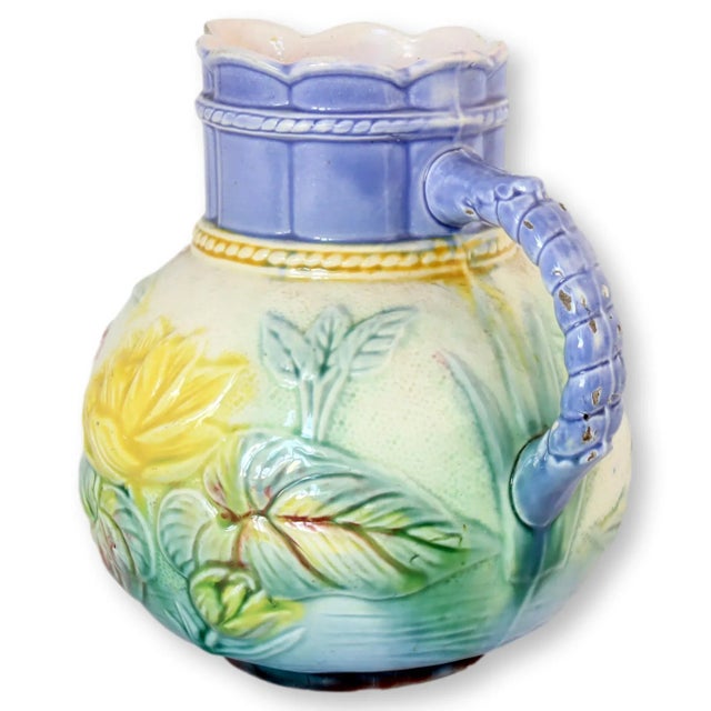 Large floral pattern English majolica pitcher. It features lavender glaze, which is unusual in antique majolica.....