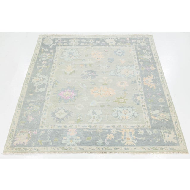 Elevate your space with the understated elegance of this Modern Oushak style rug. Meticulously hand-knotted from high-...