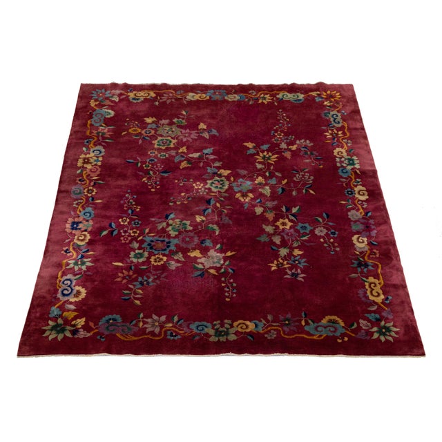 This antique Chinese Art Deco rug is hand-knotted in wool. It features a red background adorned with a multicolored floral...