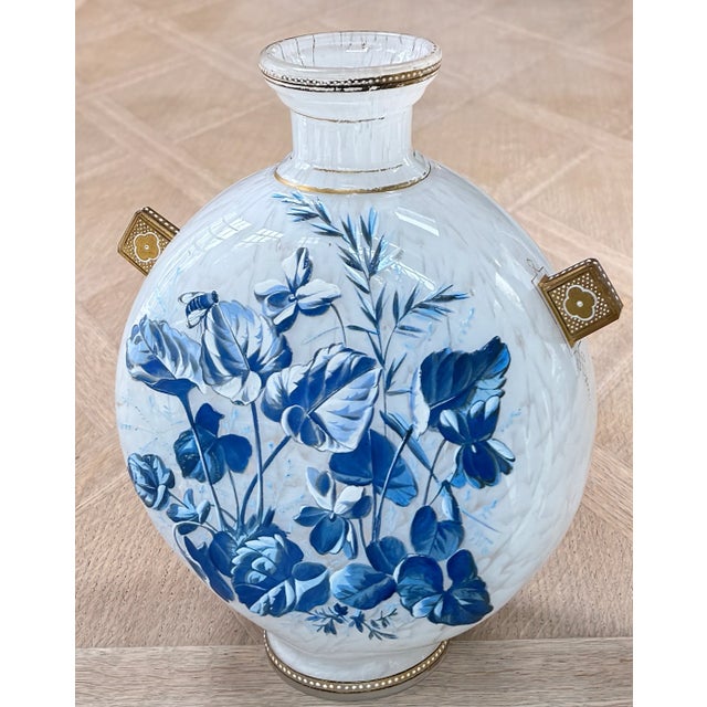 Bohemian enmeled glass pilgrim vase, circa 1890, with raised cobalt florals, gilt quatrefoil handles, and marbled body. In...
