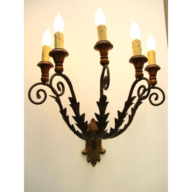 A pair of 19th-century wrought iron sconces, five curved arms decorated with leafy elements and ending with bobeches, a...