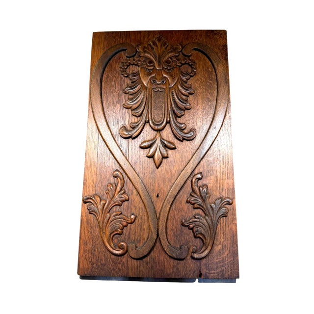 Antique carved oak architectural panel wall art featuring an expressive grotesque mask surrounded by sweeping foliate and...