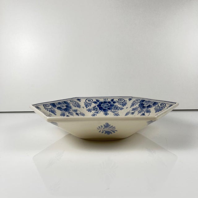 Delftware deep dish, hand-decorated with an elegant blue floral motif on a white background. Polygonal in shape, it...