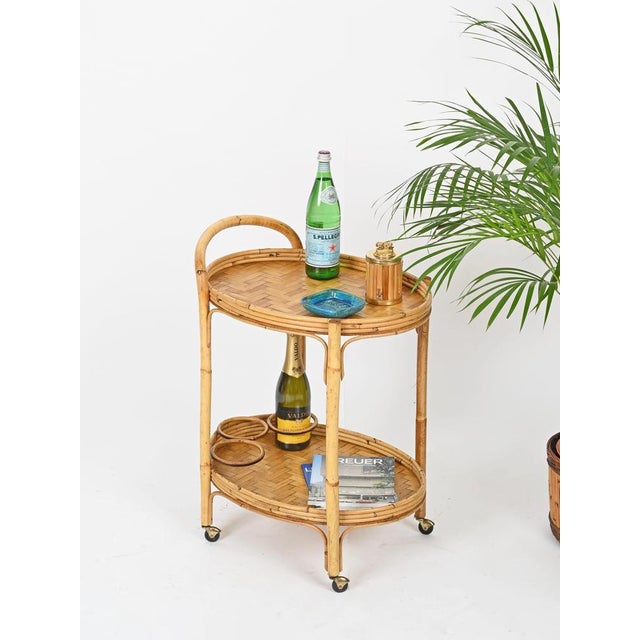 Marvelous mid-century oval bar cart, crafted entirely in curved rattan and bamboo. This stylish organic bar cart was...