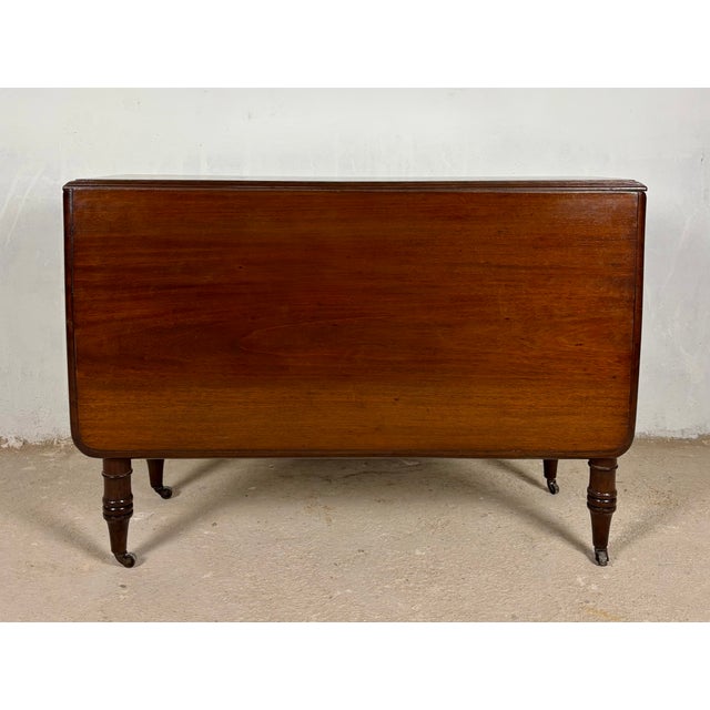 Spanish drop-leaf dining table dating from the 1930s. Crafted in wood, it features two folding leaves that allow it to be...
