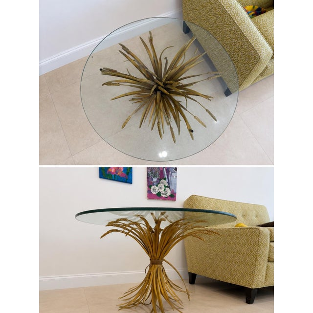 Striking vintage Hollywood Regency coffee table featuring an ornate sculptural wheat sheaf base in a warm gilt gold finish...