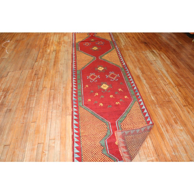An exuberant early 20th century Turkish runner. Bright reds, orange, green and blue. Measures: 3' x 10'11''.
