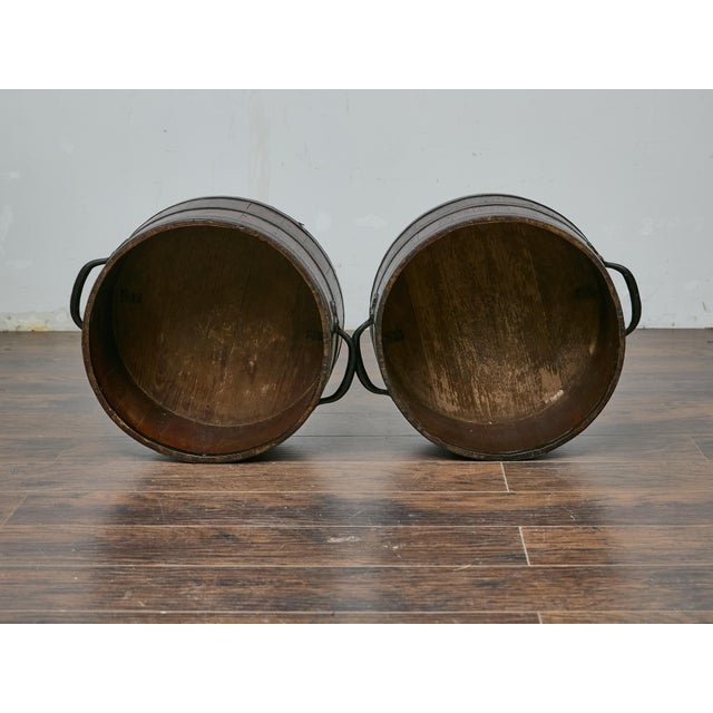 This pair of antique English bushel measures brings a sense of rustic charm and historical authenticity to any space....