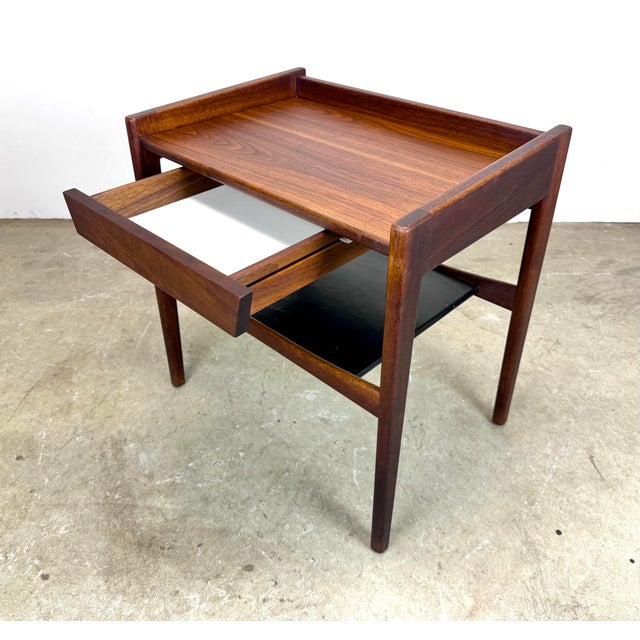 A walnut Jens Risom nightstand with floating drawer and black leatherette covered lower shelf, circa 1960’s. Unsigned. Top...