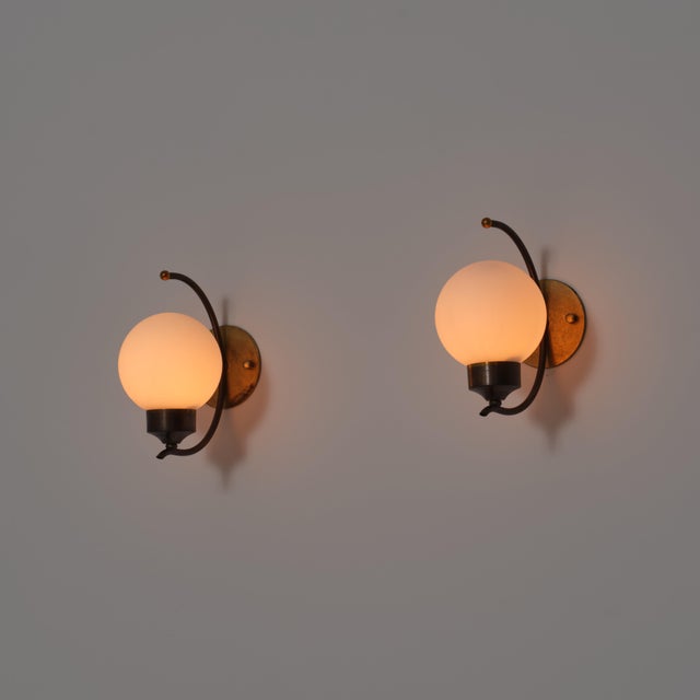 A refined pair of italian wall sconces from the 1950s, characterized by a graceful and sculptural composition entirely in...