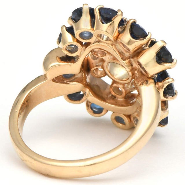 Almost 5 carats of blue and clear stones in a variety of shapes emulate a royal display of color sitting atop eloquent 14K...