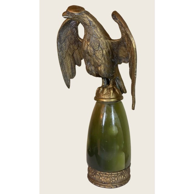 Antique cast gilt bronze eagle flag topper featuring a detailed spread-wing design mounted on a polished green onyx base....