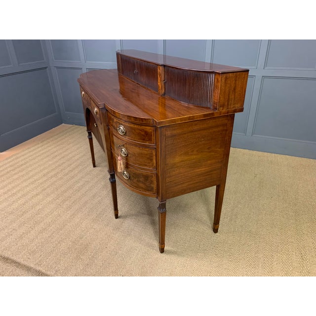 A large and imposing George III, Sheraton period, inlaid mahogany sideboard. Of generous proportions and of break-fronted...