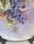 A captivating example of early 20th-century artistry, this hand-painted porcelain plate showcases lush grape clusters in...