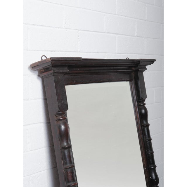 This wooden mirror frame from India showcases a beautifully aged dark finish and 20th-century craftsmanship. The frame...