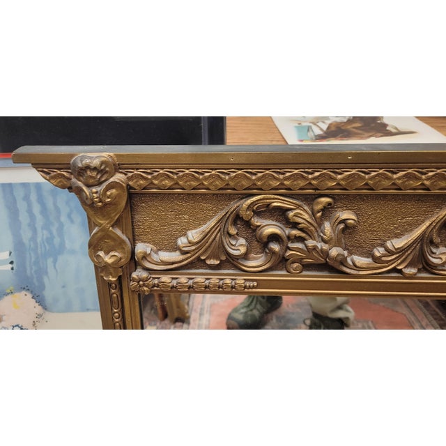 Fine diminutive French Rococo style mantel mirror. Features a raised decorative embellished frame made ofcwood and...