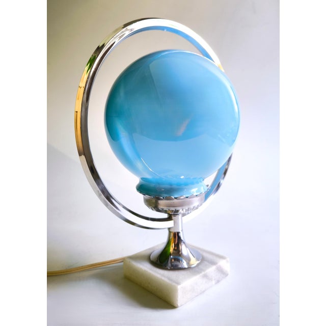 An exceptional sculptural table lamp that blends the geometric elegance of the Art Deco movement with the orbital forms...