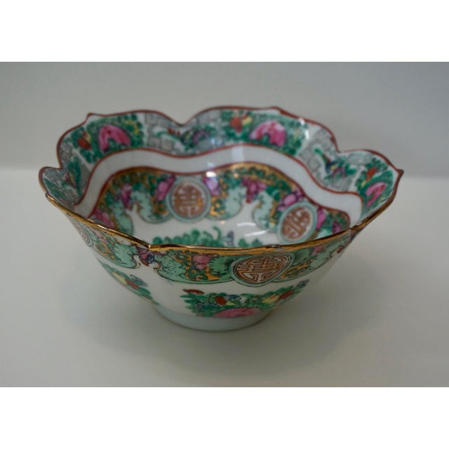 This exquisite mid-century porcelain bowl features a scalloped rim and a traditional "Rose Cantonese" style palette. The...