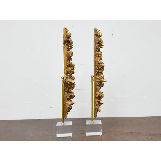 Rich in detail and decorative presence, this pair of 19th-century giltwood carvings presents a lush cascade of roses and...