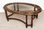 A vintage Regency Revival oval coffee table, circa 1970s, with a richly figured wood frame and an inset beveled glass top....