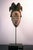 Mask originating from the Punu culture in Gabon. The triangular face is dominated by a wide headdress with a central...