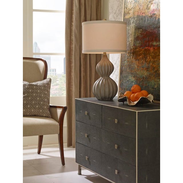 Delphine lamp features a modern style fluted gourd cast composite base. The natural concrete paint gives a masculine...