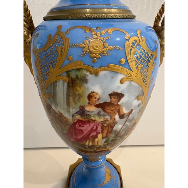 Visually stunning pair of late 19th Century French Manufacture de Sevres urns in popular Bleu Celeste color with gilt...