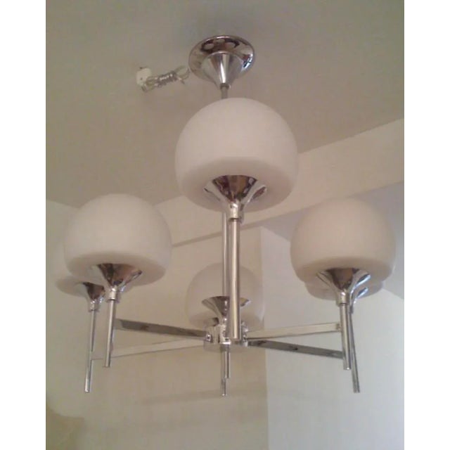A 1960s six light polished chrome and white opaline glass shade chandelier by the famed Italian lighting maker, Reggiani...