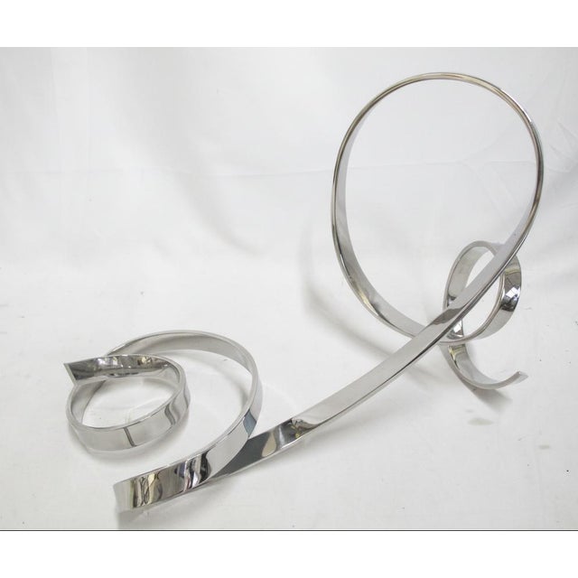 David Herschler, free standing chromed metal ribbon twist modern art sculpture. Measures approximately 20" x 10" x 10"...