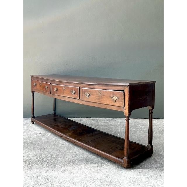 This remarkable 18th-century English Country console table is a masterclass in rustic elegance and historic soul. Expertly...