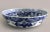 Japanese blue and white porcelain round bowl boldly decorated inside with raised designs of a prunus tree, branches and...