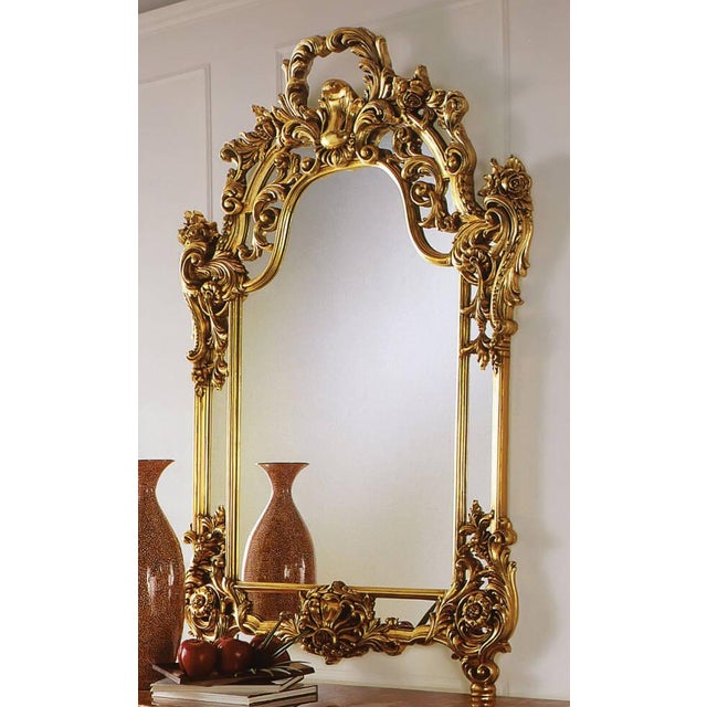 Hand crafted in Italy. Solid wood. Hand carved. Beveled clear glass mirror. 24 Karat antique gold leaf finish with brown...