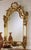 Hand crafted in Italy. Solid wood. Hand carved. Beveled clear glass mirror. 24 Karat antique gold leaf finish with brown...