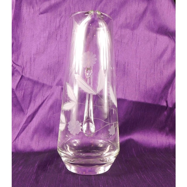This is a clear glass drink pitcher with an etched flower and leaf design. Honestly, the leaves are much larger and more...