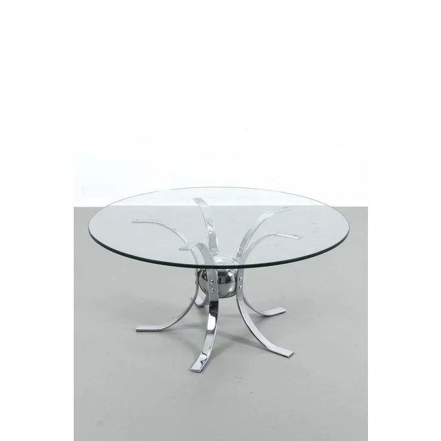 Sleek coffee table made of chrome with a sphere and glass table top. Has some spots and scratches on the glass table top....