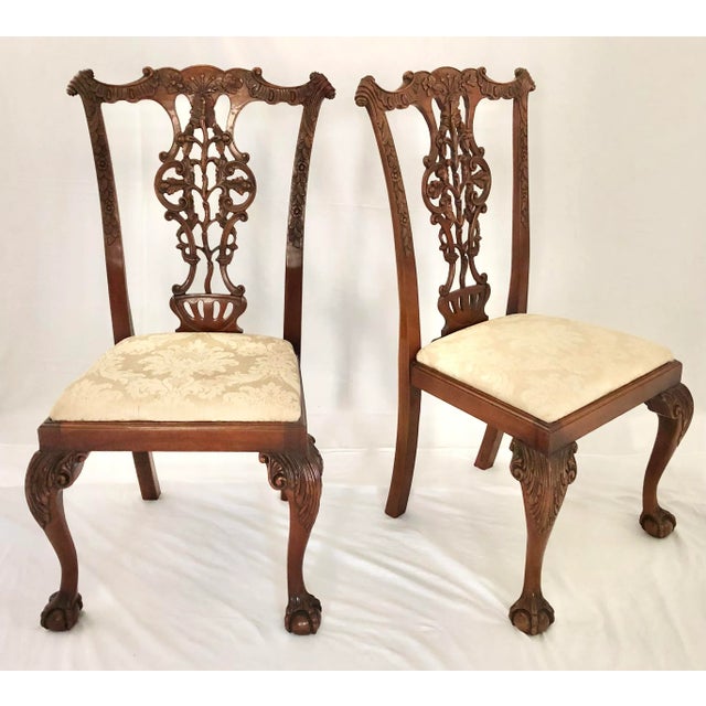 An English, Early 20th c. set of Twelve Hand Carved Chippendale Style Mahogany Dining Chairs, consisting of 2 Arm Chairs...