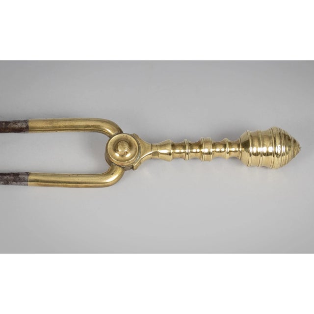 18th Century brass and steel fireplace tongs with brass spool turned handle incorporating steel arms with penny ends.