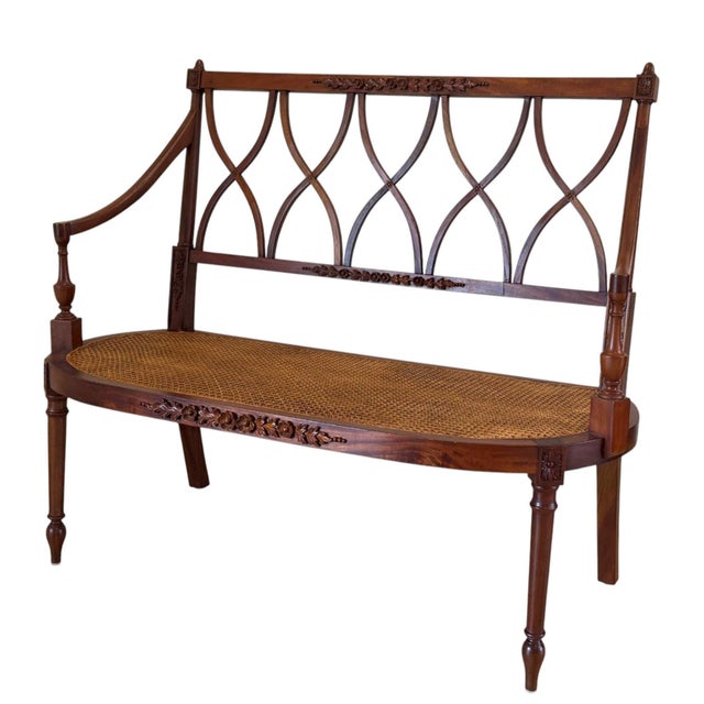 Vintage late 20th-century Regency style bench. Features richly carved floral details with opposing lancet arch splats...