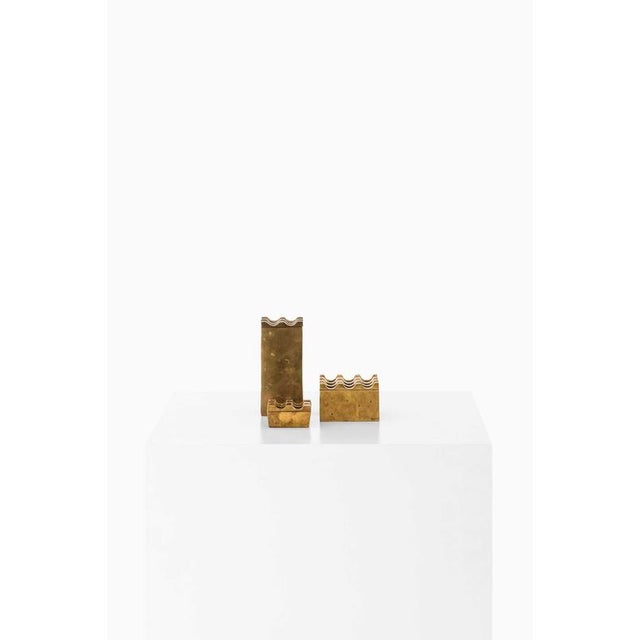 This set of three brass ashtrays, produced in sweden, reflects the understated sophistication and material focus typical...